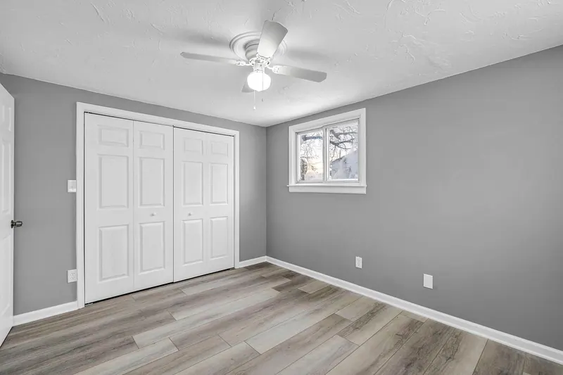 Bedroom with a double closet beside the window