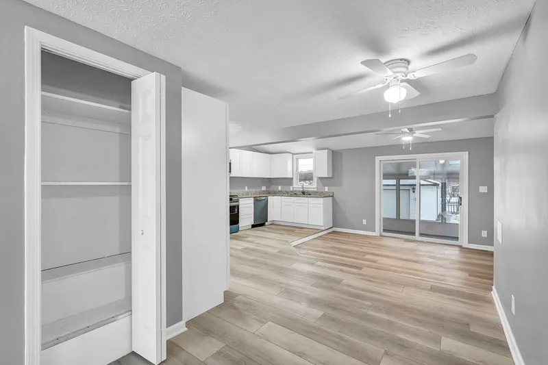 Hallway with a linen closet, looking through to the kitchen