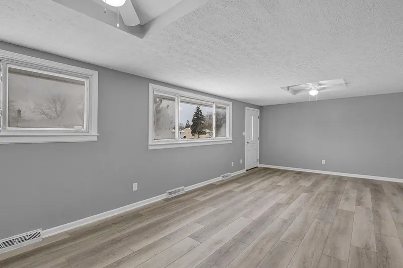 Living room with two windows and a side door