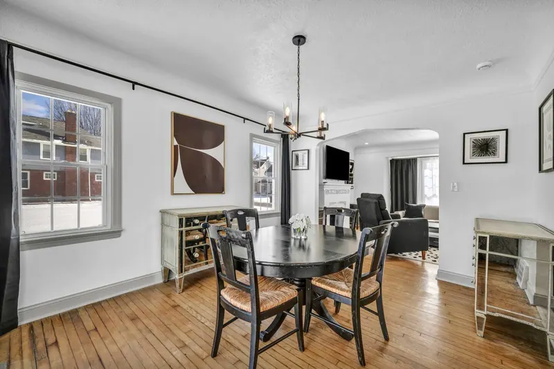 Dining room with an oval table, six chairs and a black chandelier