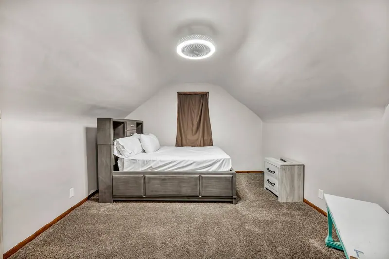 Upstairs bedroom with a queen bed under a sloped ceiling