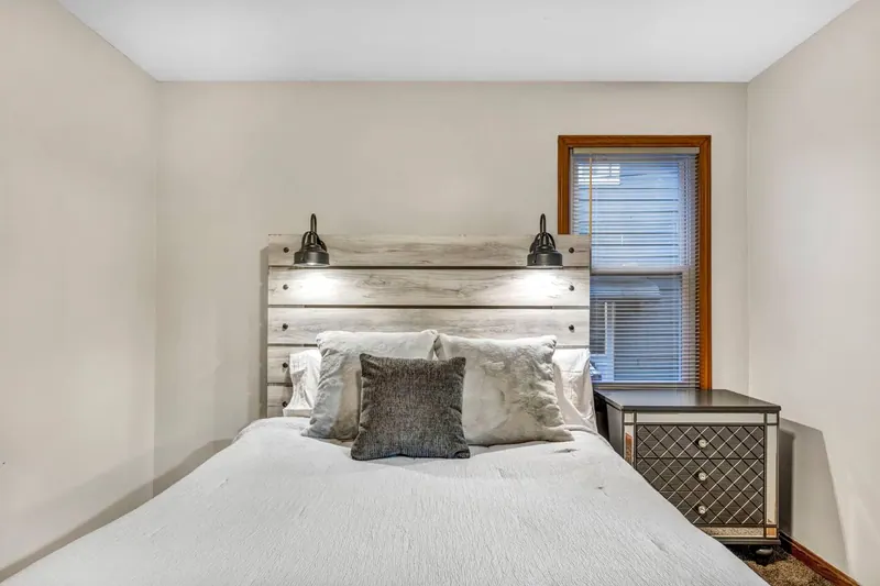Bedroom with a queen bed, a plank headboard and reading lights