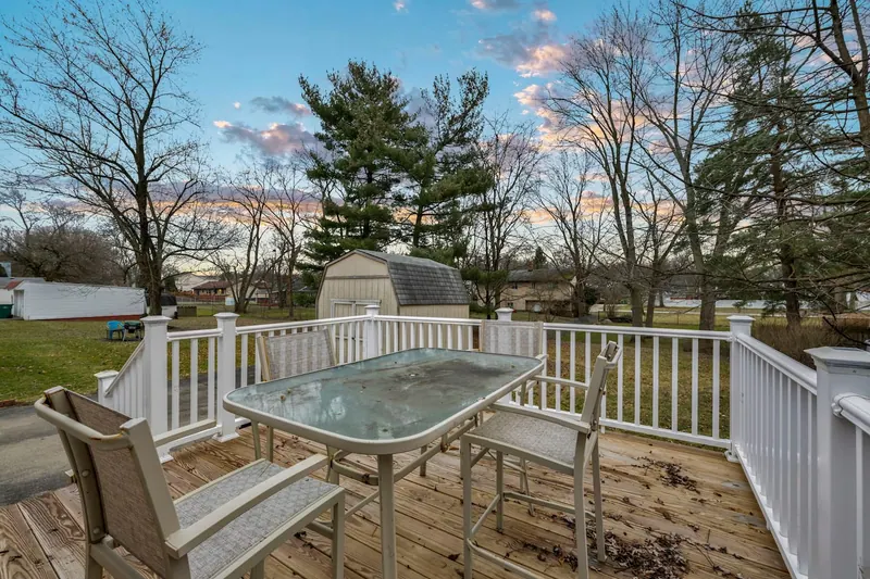 Back deck with a patio table and chairs looking onto the yard