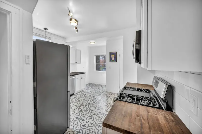 Kitchen from the other end, with a gas range and a stainless refrigerator