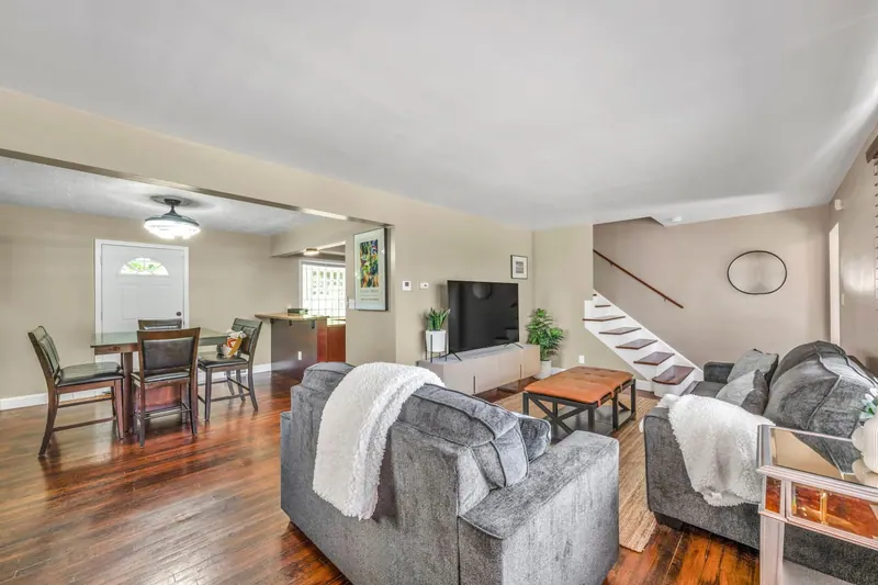 Living room with gray sofas and a television, open through to the dining room