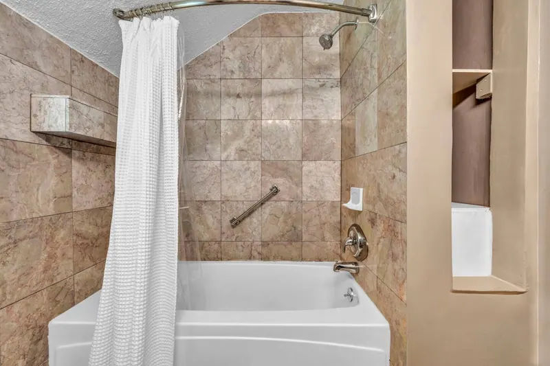Bathroom with a tiled tub and shower