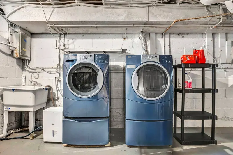 Basement laundry with a washer, a dryer and a utility sink