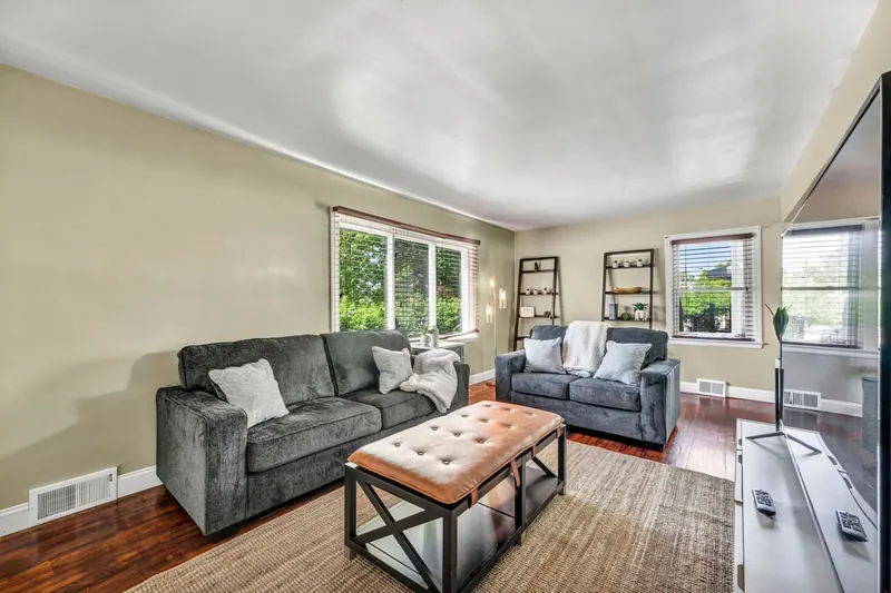 Living room from the far side, with windows along two walls and open shelving