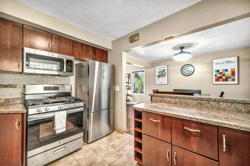 Kitchen with a gas range, a stainless refrigerator and cherry cabinets